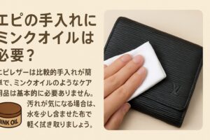 代替テキスト:黒いエピレザーのルイヴィトン財布を柔らかい白い布で拭いている様子と、「エピの手入れにミンクオイルは必要?」という日本語のタイトル、および注意書きが添えられたケアガイド画像。